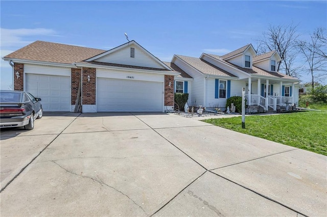 view of front facade featuring an attached garage, concrete driveway, a front yard, a porch, and brick siding