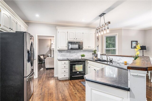 7325 Oakview St, Shawnee, KS 66216 - kitchen with black appliances, a peninsula, dark countertops, crown molding, and dark wood finished floors