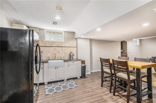 7325 Oakview St, Shawnee, KS 66216 - kitchen with freestanding refrigerator, light wood-style flooring, recessed lighting, dark countertops, and white cabinets