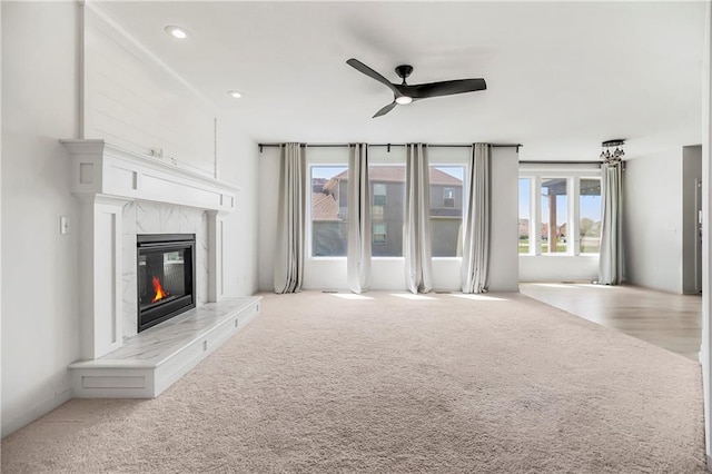 unfurnished living room with a ceiling fan, carpet flooring, a fireplace, and recessed lighting