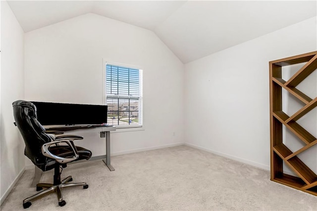 carpeted office with lofted ceiling and baseboards