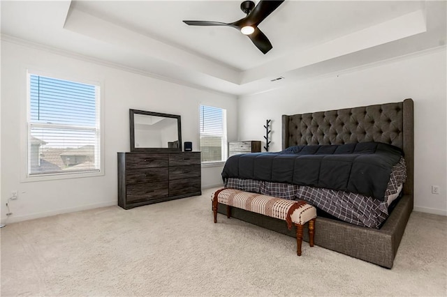 carpeted bedroom with ceiling fan, baseboards, visible vents, and a raised ceiling