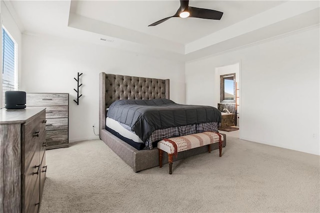 bedroom featuring visible vents, a ceiling fan, a tray ceiling, and light colored carpet