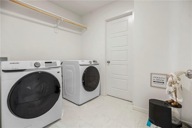 laundry room featuring washing machine and dryer, baseboards, marble finish floor, and laundry area
