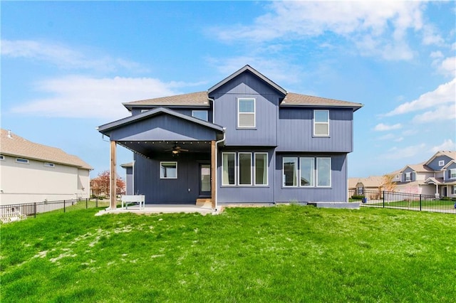 back of property with a yard, a ceiling fan, a patio area, and a fenced backyard