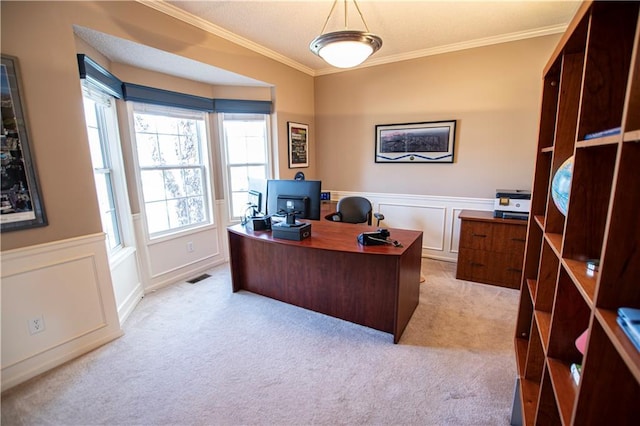 office featuring ornamental molding, light colored carpet, a wainscoted wall, and a decorative wall