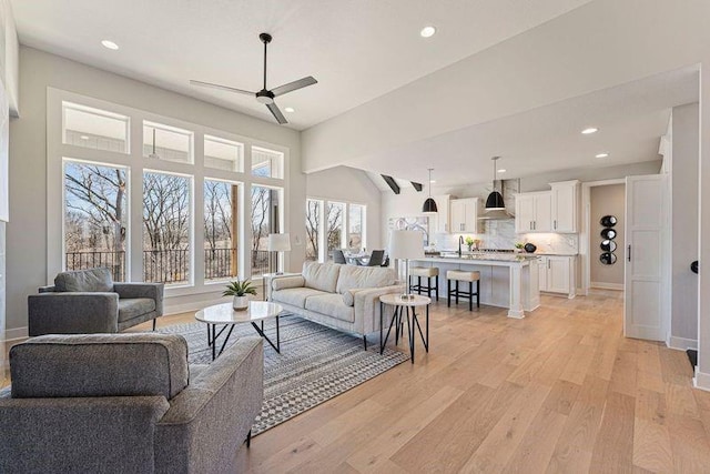 living room with ceiling fan, light wood-style flooring, recessed lighting, and baseboards