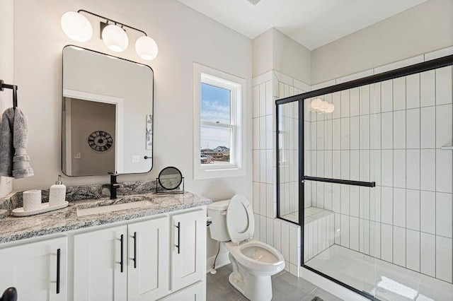 bathroom featuring a shower stall, toilet, vanity, and tile patterned floors