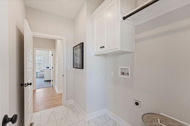 laundry area with hookup for an electric dryer, cabinet space, washer hookup, light marble finish flooring, and baseboards