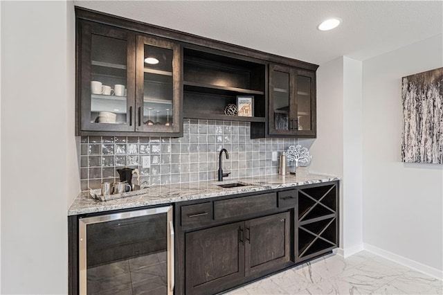 indoor wet bar with wine cooler, light marble finish floors, backsplash, baseboards, and recessed lighting