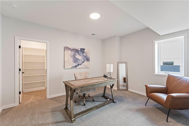 carpeted home office with baseboards