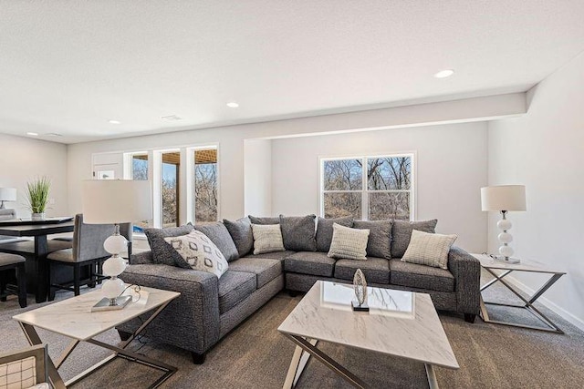 living area with plenty of natural light, dark carpet, recessed lighting, and baseboards
