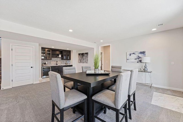 dining space with wine cooler, bar area, light carpet, recessed lighting, and baseboards