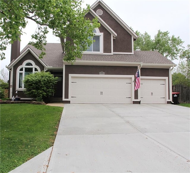 craftsman-style house with stucco siding, an attached garage, driveway, and a front lawn