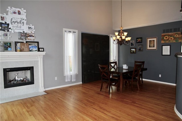 dining room featuring baseboards, wood finished floors, and a notable chandelier