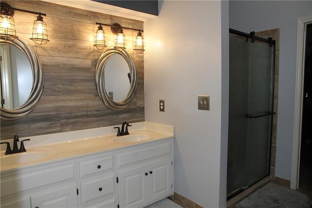 full bath with double vanity, a sink, a shower with door, and baseboards
