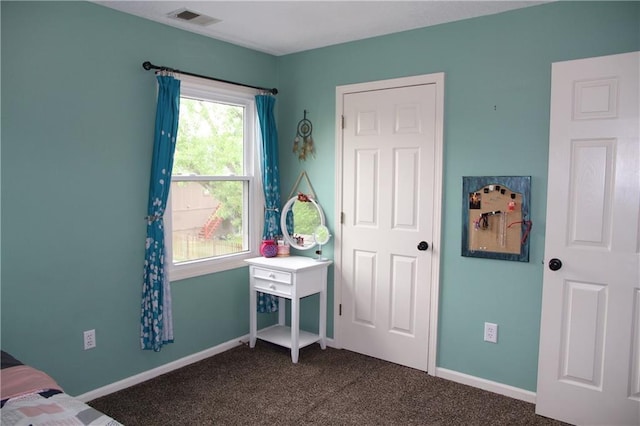 bedroom with baseboards, visible vents, and dark colored carpet