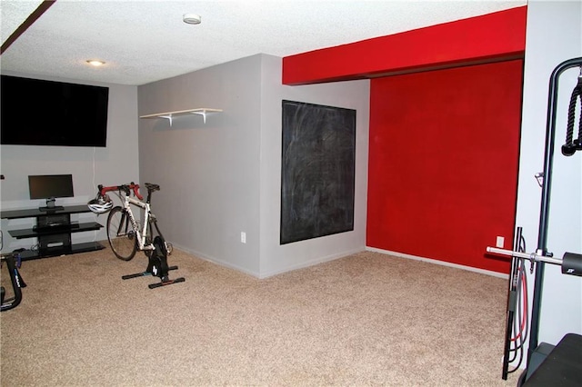 workout room with carpet floors, a textured ceiling, and baseboards