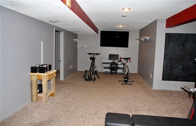 exercise room with carpet floors and a textured ceiling