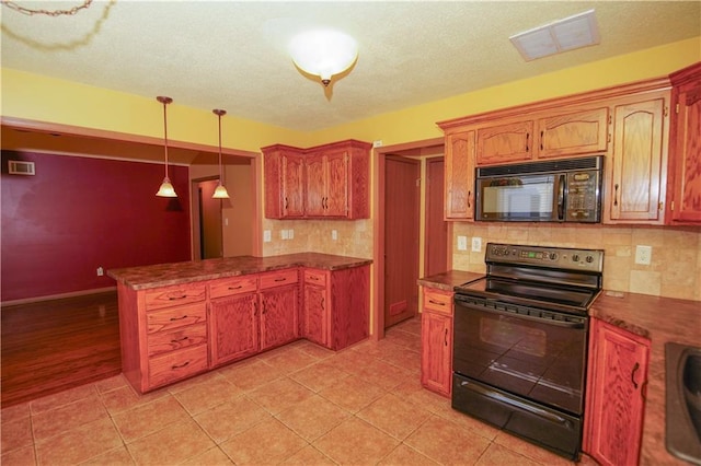 kitchen with a peninsula, visible vents, black appliances, and dark countertops