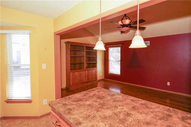 unfurnished dining area with plenty of natural light, visible vents, baseboards, and ceiling fan
