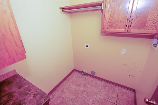 laundry room featuring cabinet space, baseboards, hookup for an electric dryer, and tile patterned flooring