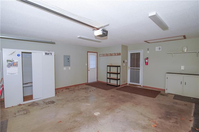 garage with a garage door opener and electric panel