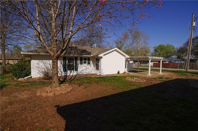 view of side of property with a pergola, a patio area, fence, and a lawn