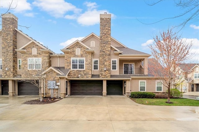 view of property with a garage, stucco siding, a chimney, and concrete driveway