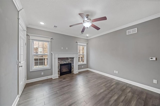 unfurnished living room with ceiling fan, a stone fireplace, dark wood-style flooring, baseboards, and crown molding