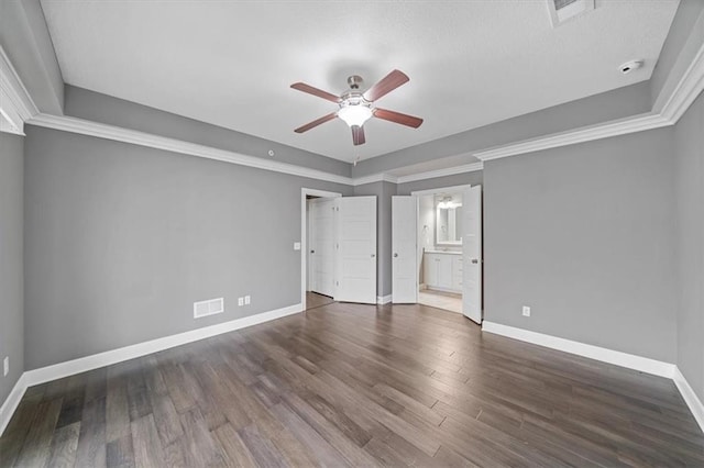 unfurnished bedroom featuring baseboards, wood finished floors, ensuite bathroom, and a ceiling fan