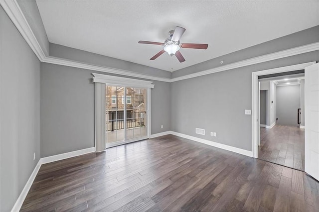 spare room featuring dark wood-style floors, ceiling fan, and baseboards