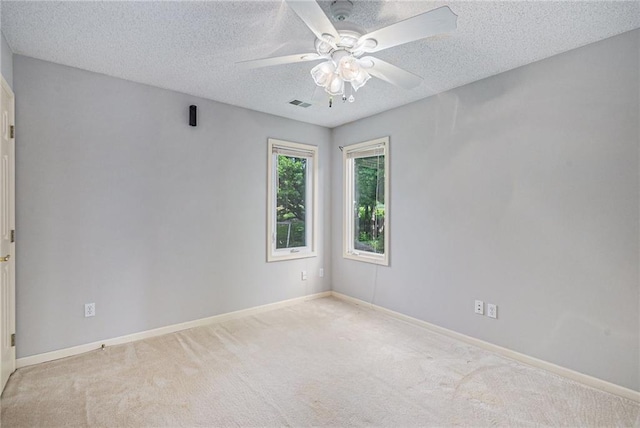 carpeted spare room with ceiling fan, a textured ceiling, and baseboards