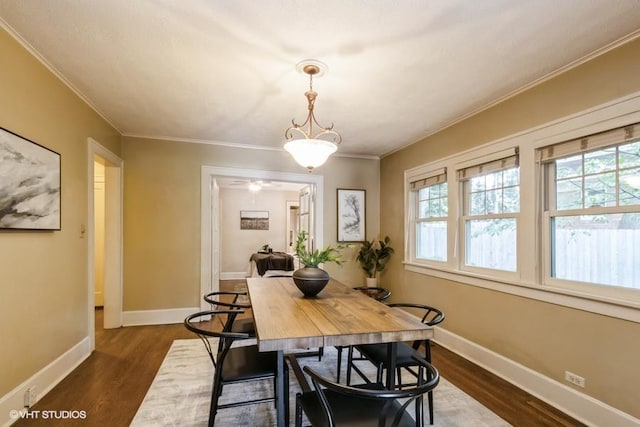 5825 Rockhill Rd, Kansas City, MO 64110 - dining area featuring dark wood-style floors, baseboards, and ornamental molding