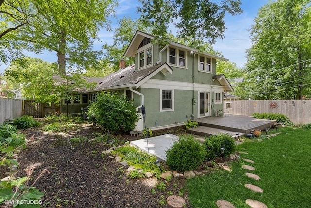 5825 Rockhill Rd, Kansas City, MO 64110 - rear view of property featuring stucco siding, a deck, and a chimney