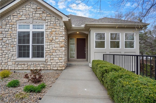 property entrance with stone siding and roof with shingles