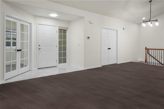 entrance foyer featuring an inviting chandelier, wood finished floors, and baseboards