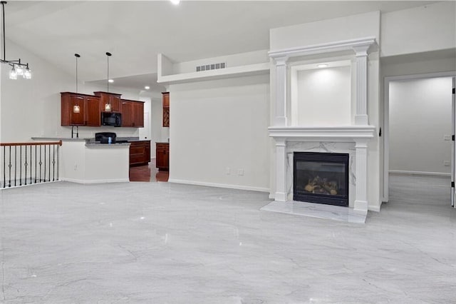 unfurnished living room featuring baseboards, visible vents, and a fireplace