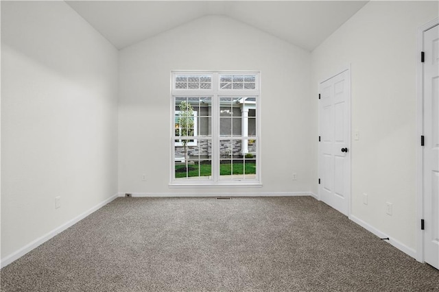 carpeted empty room with vaulted ceiling and baseboards