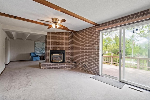 19864 211th St, Tonganoxie, KS 66086 - unfurnished living room with beamed ceiling, carpet, a fireplace, ceiling fan, and a textured ceiling