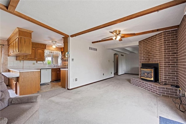 19864 211th St, Tonganoxie, KS 66086 - unfurnished living room featuring ceiling fan, light colored carpet, beam ceiling, baseboards, and a brick fireplace