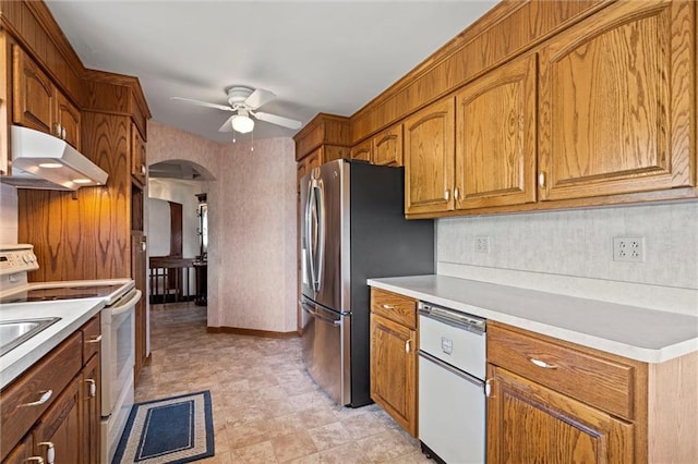 19864 211th St, Tonganoxie, KS 66086 - kitchen with under cabinet range hood, white appliances, arched walkways, ceiling fan, and light countertops