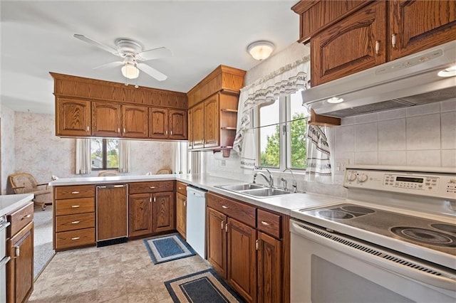 19864 211th St, Tonganoxie, KS 66086 - kitchen featuring white appliances, under cabinet range hood, a sink, brown cabinetry, and backsplash