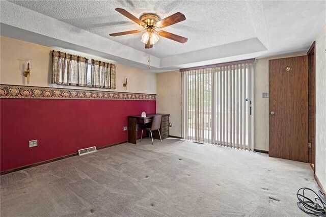 19864 211th St, Tonganoxie, KS 66086 - empty room with a tray ceiling, a textured ceiling, a ceiling fan, and carpet flooring