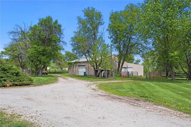 19864 211th St, Tonganoxie, KS 66086 - view of front of house featuring a detached garage, an outdoor structure, and driveway
