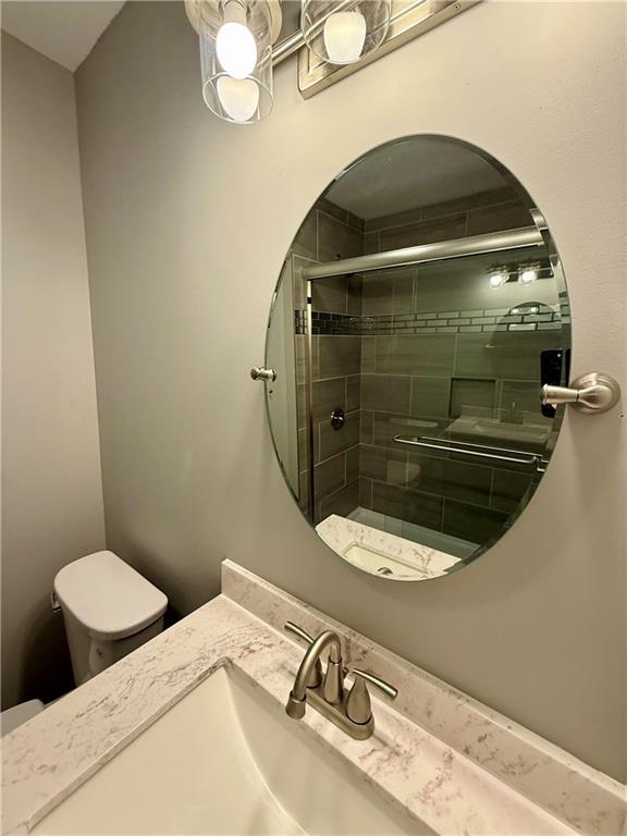 112 Benton St, Pleasant Hill, MO 64080 - bathroom with toilet, tiled shower, and vanity
