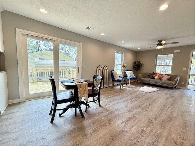 112 Benton St, Pleasant Hill, MO 64080 - dining room with visible vents, baseboards, light wood-type flooring, and a healthy amount of sunlight