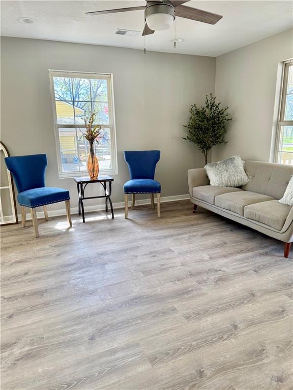 112 Benton St, Pleasant Hill, MO 64080 - living area featuring visible vents, baseboards, a ceiling fan, and wood finished floors