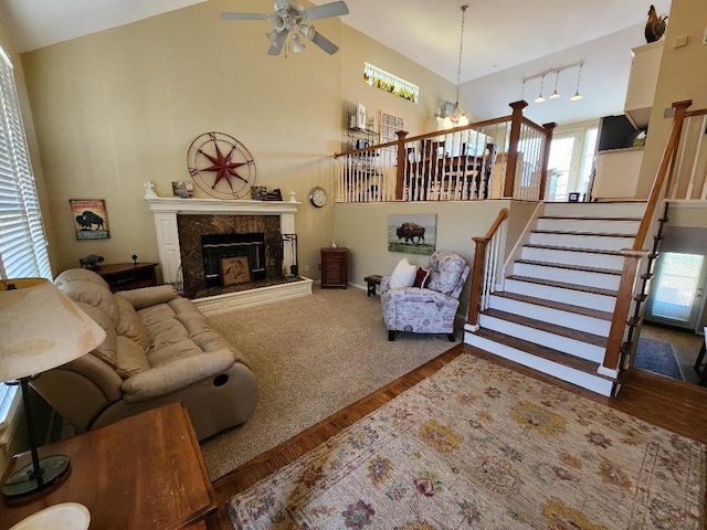 5773 Meadow Heights Dr, Shawnee, KS 66226 - living area featuring a fireplace, a chandelier, wood finished floors, ceiling fan, and stairs