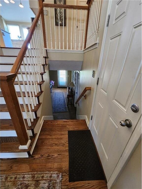5773 Meadow Heights Dr, Shawnee, KS 66226 - stairway featuring baseboards, wood finished floors, and a towering ceiling